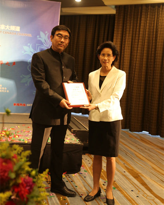 人民日報海外版副總編輯劉玉琴為加拿大頻道執(zhí)行總編、中華傳媒集團(tuán)董事長常建國授牌。（呂文寶 攝）.jpg