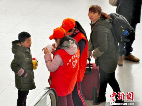 鐵路青年志愿者為攜帶兒童出行的旅客提供咨詢解答。吳正琪攝