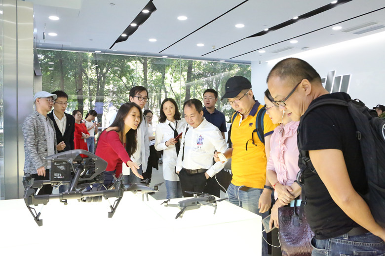 媒體采訪團(tuán)認(rèn)真聽(tīng)取工作人員介紹大疆無(wú)人機(jī)產(chǎn)品.jpg