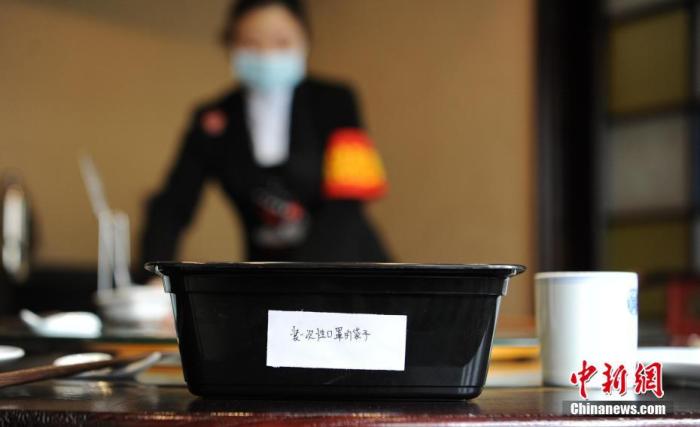 資料圖：一家餐飲店為食客準(zhǔn)備了存放一次性口罩的塑料袋。a target='_blank' href='http://www.chinanews.com/'中新社/a記者 劉忠俊 攝