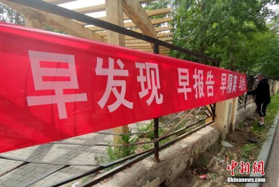 6月16日，北京花鄉(xiāng)地區(qū)一街道邊，工作人員正在懸掛防疫宣傳橫幅。a target='_blank' href='http://www.chinanews.com/'中新社/a記者 張宇 攝