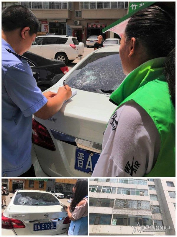 麗景社區(qū)網(wǎng)格員張羊平和郝小清在排查中發(fā)現(xiàn)有樓層墜物砸壞了車窗，報警處理。王燕華攝.jpg