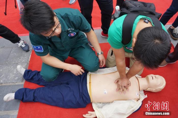資料圖：一位學(xué)生在志愿者的幫助下學(xué)習(xí)心肺復(fù)蘇術(shù)。 董曉斌 攝