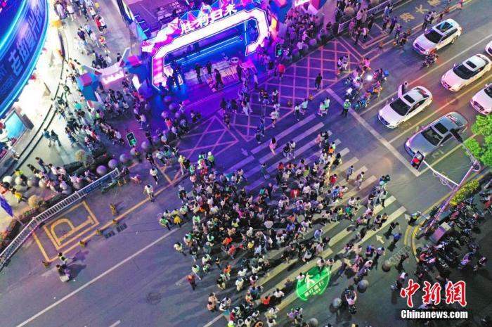 5月2日晚，江西南昌，民眾在勝利路步行街休閑購物。為恢復(fù)百年老街的往日繁華，當(dāng)?shù)亻_展勝利路步行街“勝利歸來” 主題活動(dòng)，打造潮玩、消費(fèi)于一體的活動(dòng)街區(qū)，“五一”假期吸引民眾，形成新的節(jié)日經(jīng)濟(jì)、夜間經(jīng)濟(jì)和文化經(jīng)濟(jì)。(無人機(jī)照片) a target='_blank' href='http://www.chinanews.com/'中新社/a記者 劉占昆 攝