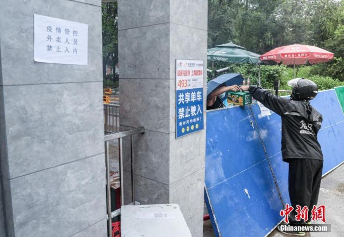7月29日，北京新增確診病例所在的居民小區(qū)已封閉，外賣人員向小區(qū)內(nèi)遞送居民購(gòu)買的生活用品。 a target='_blank' href='http://www.chinanews.com/'中新社/a記者 賈天勇 攝