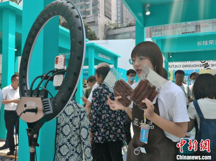 圖為“巫姑臘味”展區(qū)工作人員正在直播。袁子寒 攝