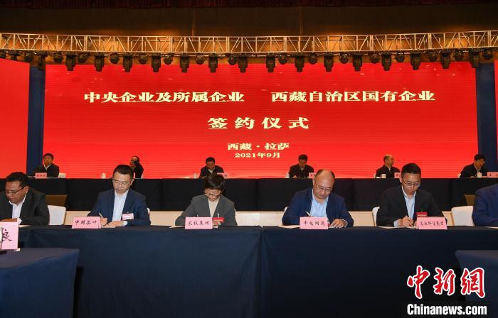 圖為8家中央企業(yè)及所屬企業(yè)與西藏自治區(qū)8家國(guó)有企業(yè)簽署合資合作協(xié)議。貢嘎來(lái)松 攝